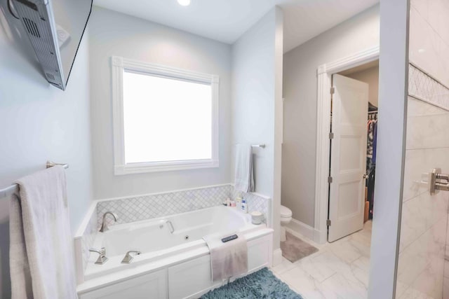 full bath featuring toilet, marble finish floor, a spacious closet, and a bath