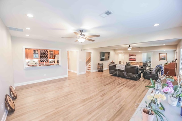 living room with stairs, light wood finished floors, visible vents, and recessed lighting