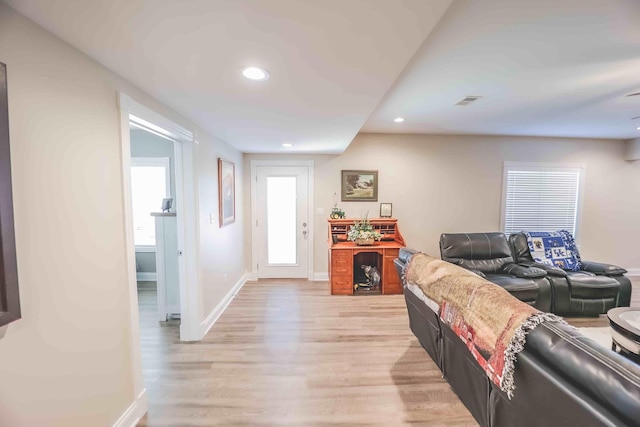 living room with baseboards, light wood-type flooring, visible vents, and recessed lighting