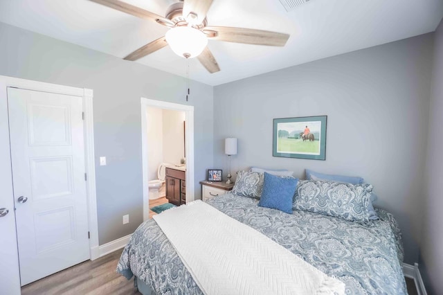 bedroom featuring ensuite bath, light wood-style flooring, baseboards, and ceiling fan