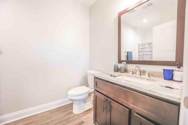 full bathroom with visible vents, baseboards, toilet, wood finished floors, and vanity