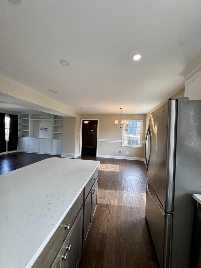 kitchen featuring dark wood-style floors, open floor plan, freestanding refrigerator, light countertops, and pendant lighting