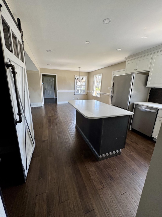 kitchen featuring light countertops, dark wood-style flooring, a notable chandelier, and stainless steel appliances