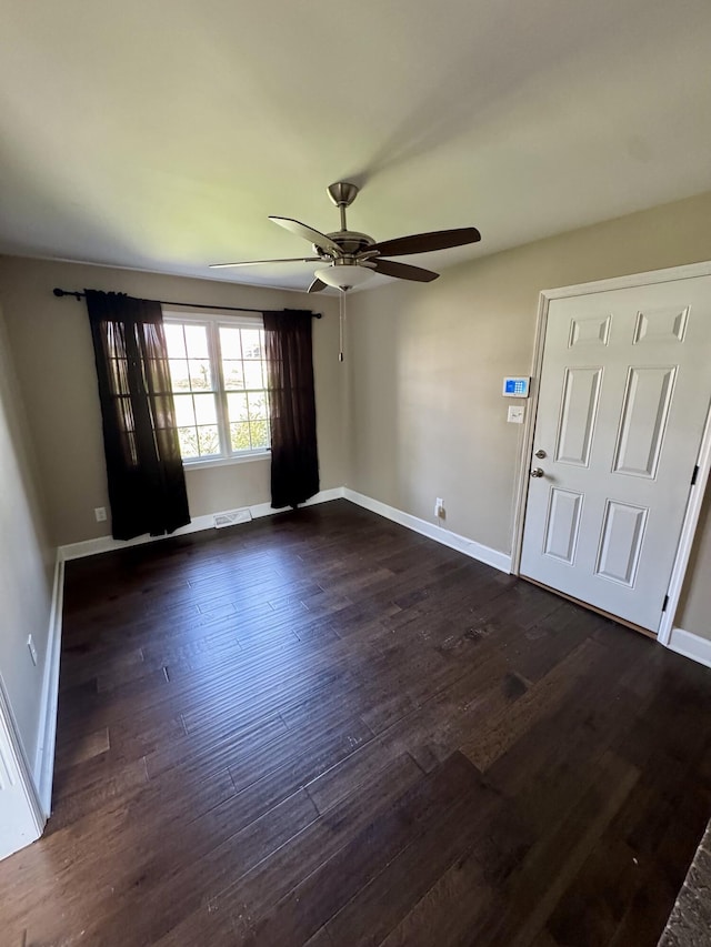 foyer featuring dark wood-style flooring, visible vents, ceiling fan, and baseboards