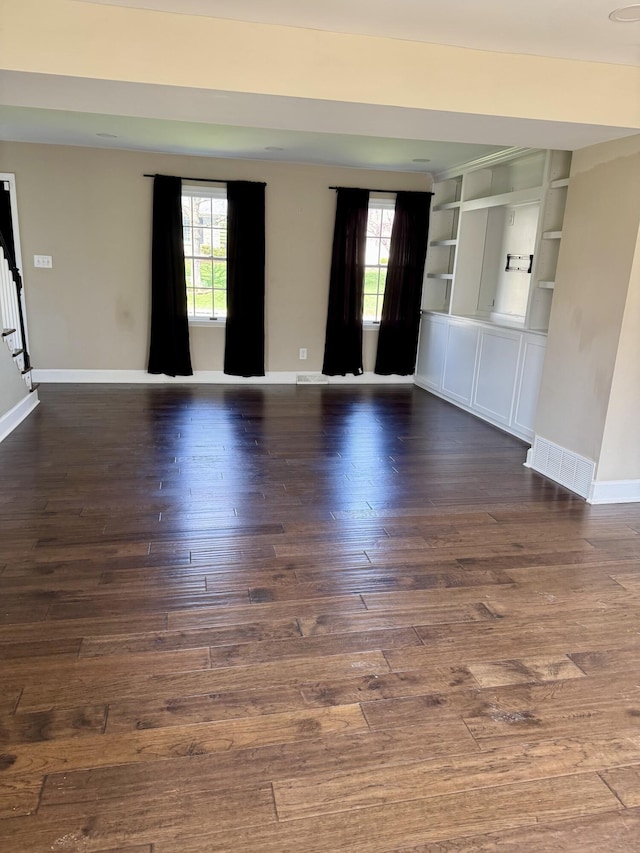 interior space with visible vents, baseboards, plenty of natural light, and dark wood finished floors