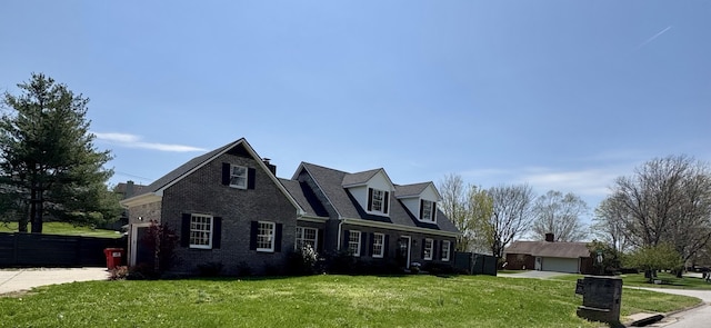 view of front of home with driveway, fence, a front lawn, and brick siding