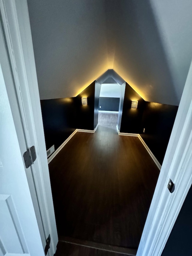 home theater room with baseboards, dark wood finished floors, and lofted ceiling