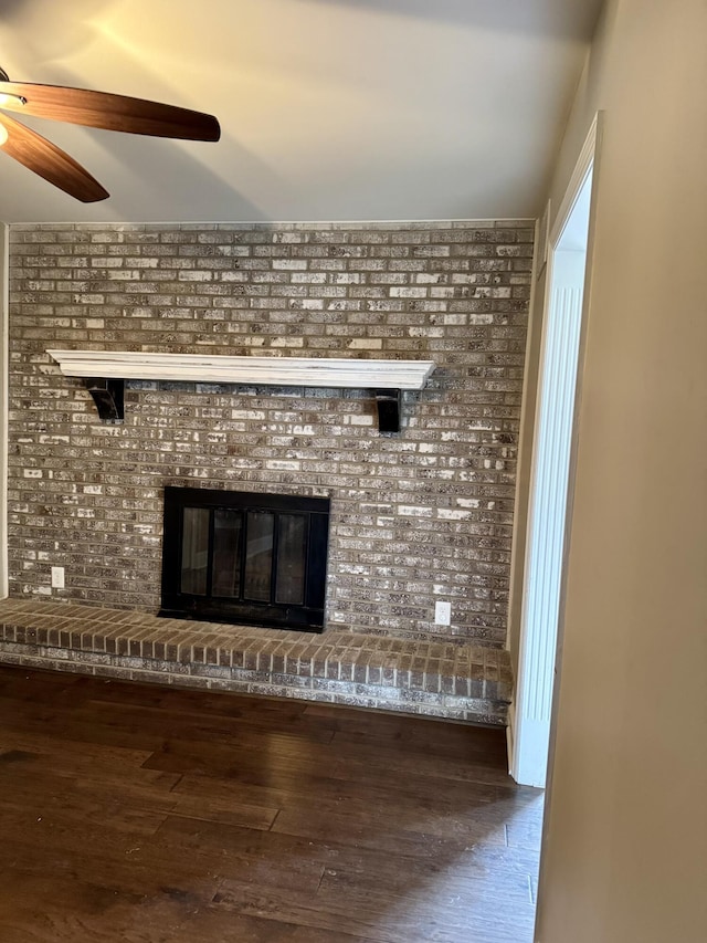 interior details featuring a brick fireplace, a ceiling fan, and wood finished floors