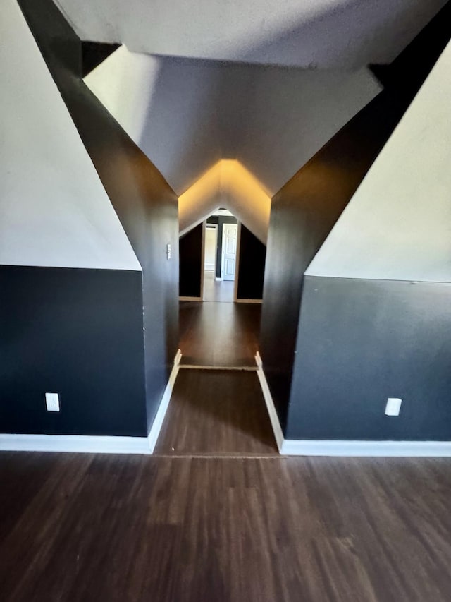 additional living space featuring baseboards, vaulted ceiling, and wood finished floors