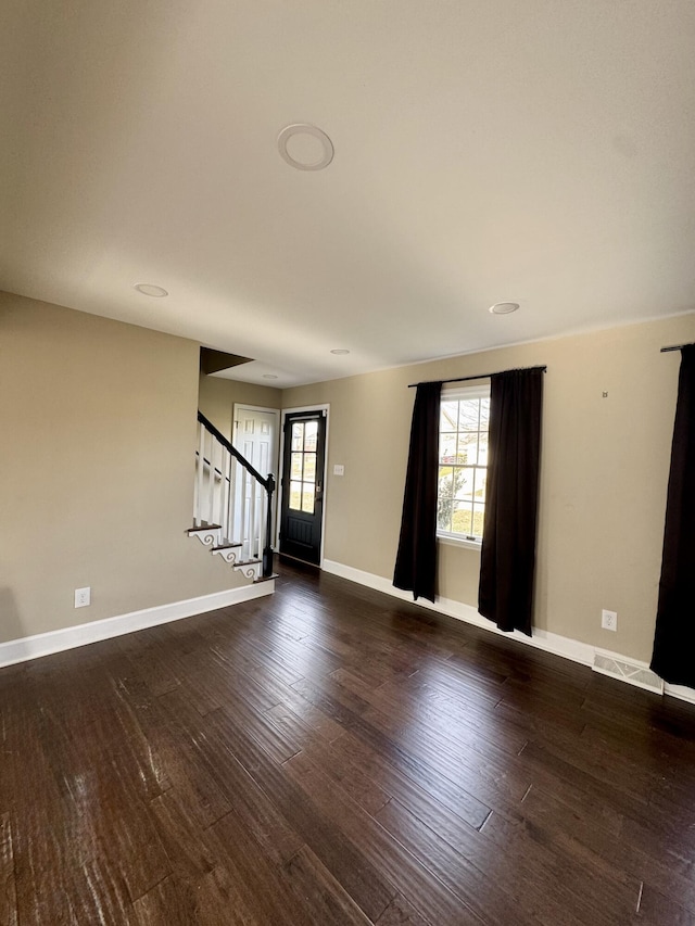 interior space featuring stairway, dark wood-style flooring, and baseboards