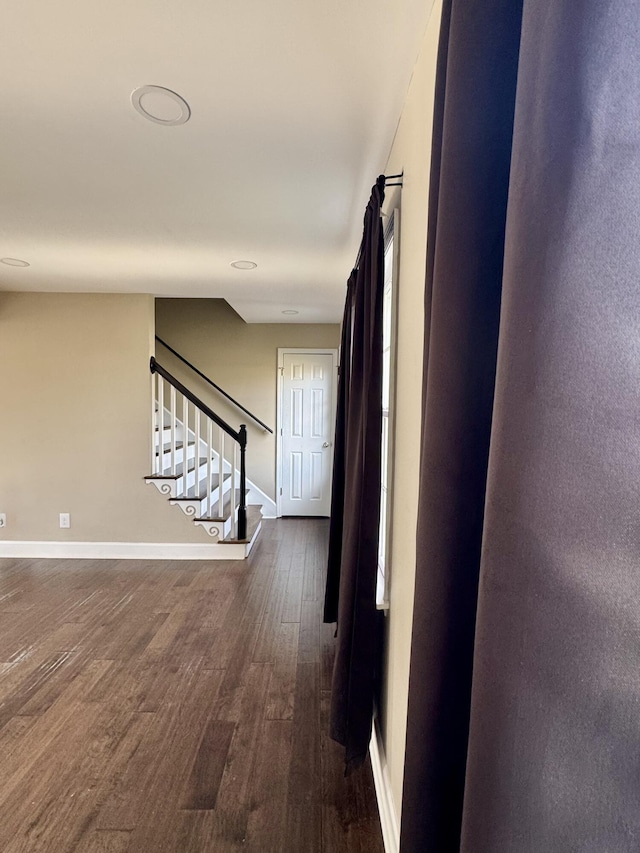 hall with stairs, baseboards, and dark wood-style flooring