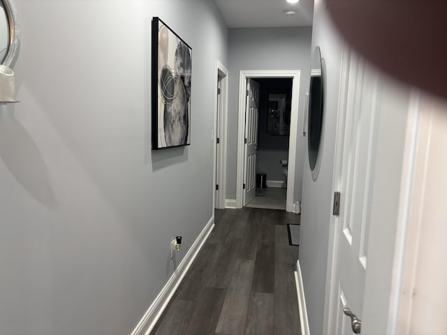 hall with baseboards and dark wood finished floors