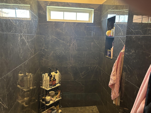 bathroom featuring tiled shower and plenty of natural light