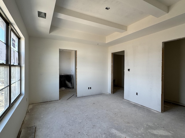 unfurnished bedroom with a raised ceiling and multiple windows