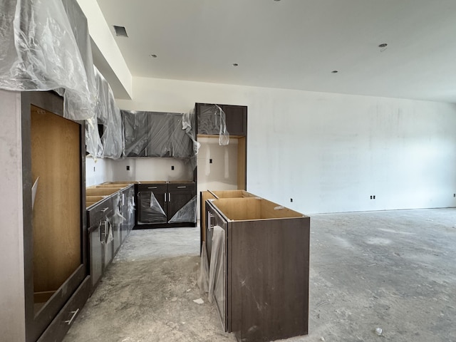 kitchen with dark brown cabinets and concrete floors