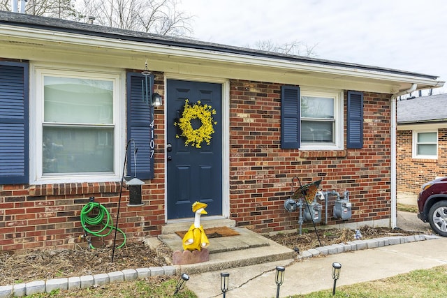 doorway to property with brick siding