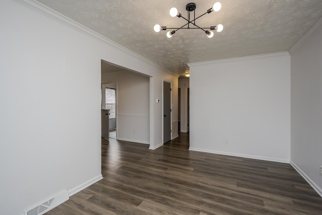 spare room with a textured ceiling, a notable chandelier, dark wood-style flooring, visible vents, and baseboards