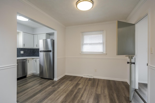 kitchen featuring white cabinetry, appliances with stainless steel finishes, dark wood finished floors, and light countertops