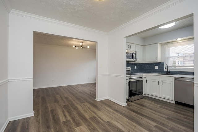 kitchen featuring stainless steel appliances, white cabinets, a sink, and crown molding