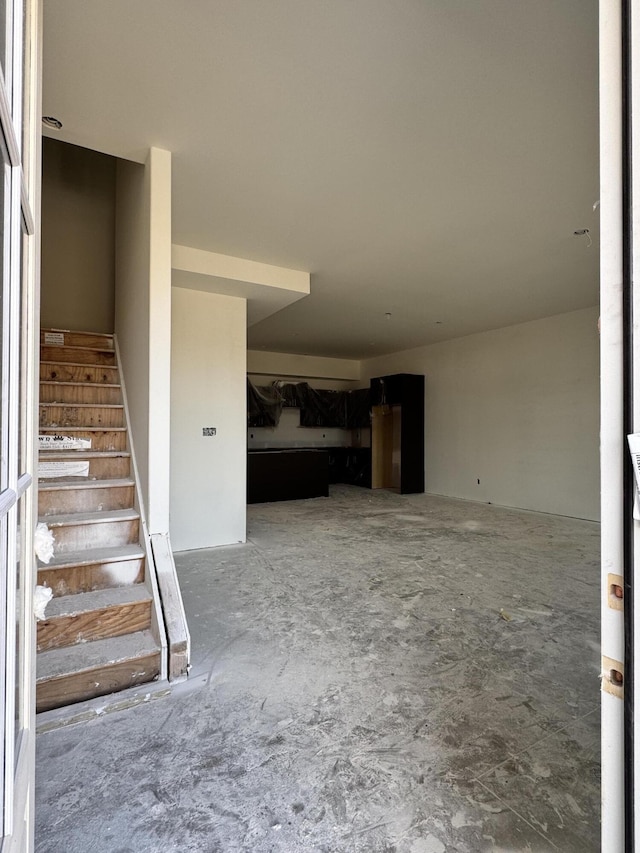 stairway featuring unfinished concrete floors