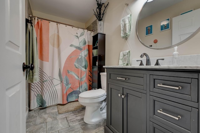 bathroom with curtained shower, stone finish floor, vanity, and toilet