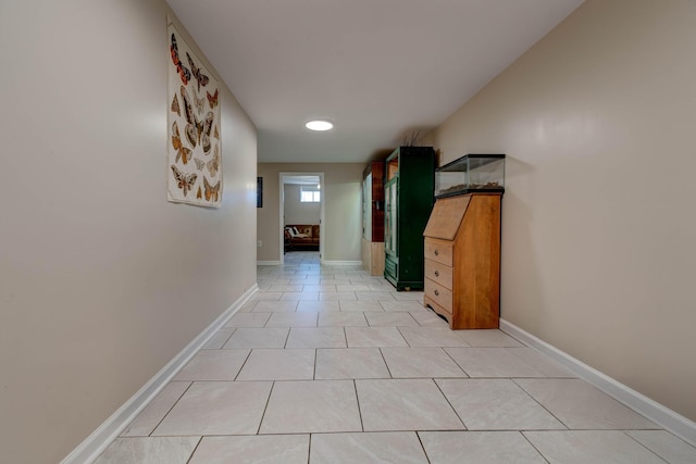 hallway featuring baseboards and light tile patterned floors