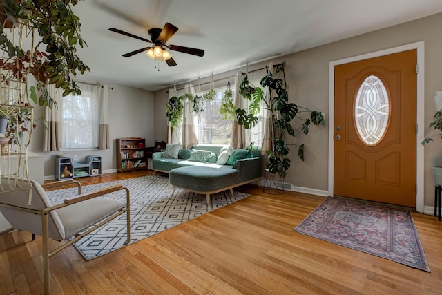 entrance foyer with a ceiling fan, plenty of natural light, baseboards, and wood finished floors