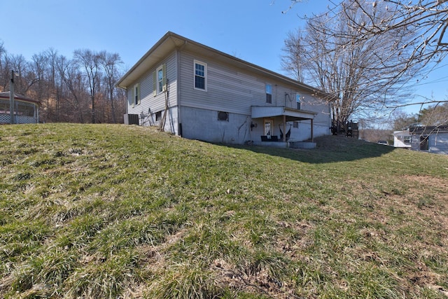 rear view of house with a lawn and central air condition unit