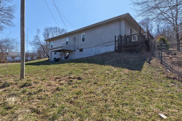 exterior space featuring fence, a lawn, and a wooden deck