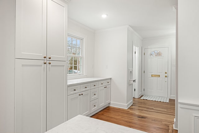 interior space with recessed lighting, crown molding, light wood-style flooring, and baseboards