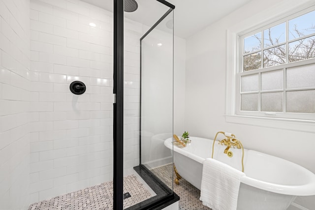 full bath featuring a stall shower and a freestanding tub