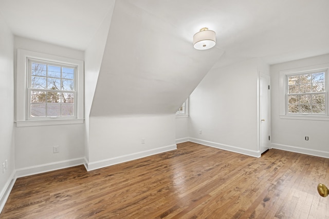 additional living space with lofted ceiling, wood-type flooring, and baseboards