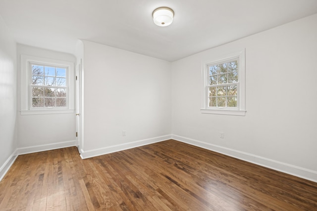 unfurnished room with baseboards, plenty of natural light, and hardwood / wood-style floors