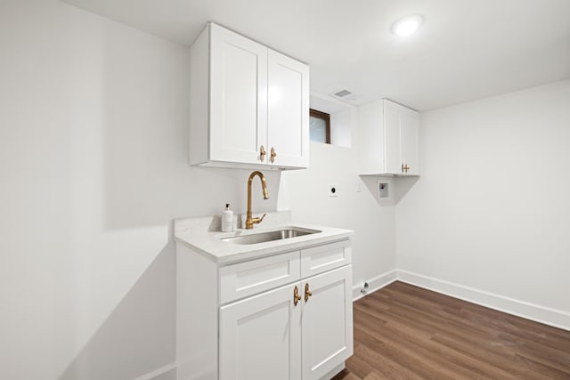 laundry room with washer hookup, cabinet space, hookup for an electric dryer, a sink, and baseboards