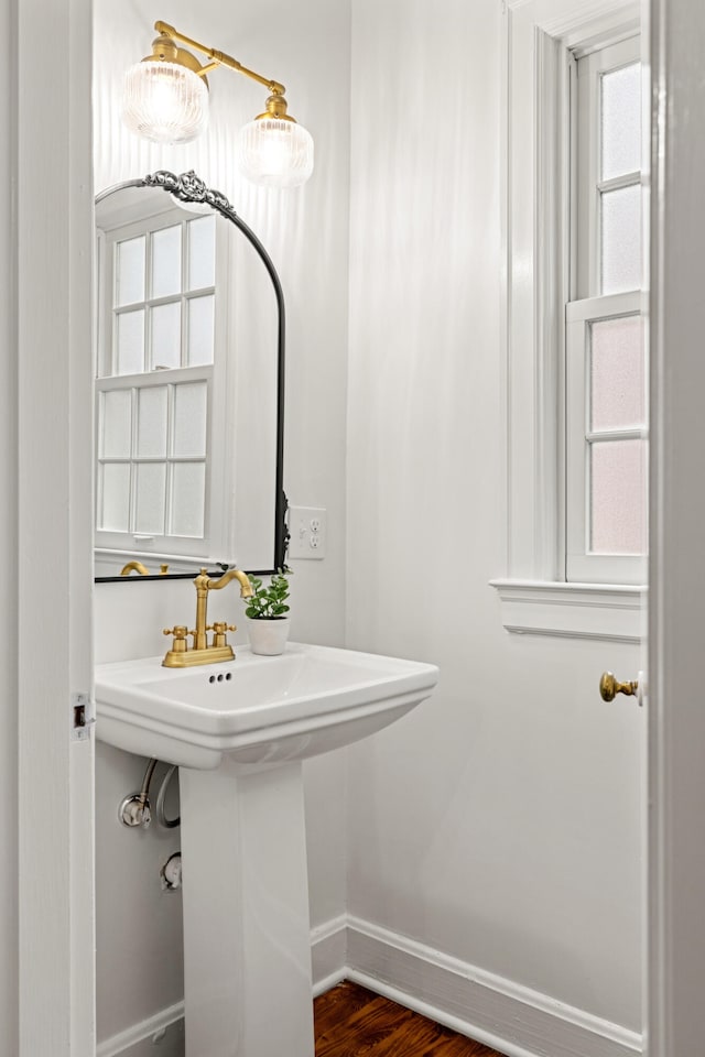 bathroom with a sink, baseboards, and wood finished floors