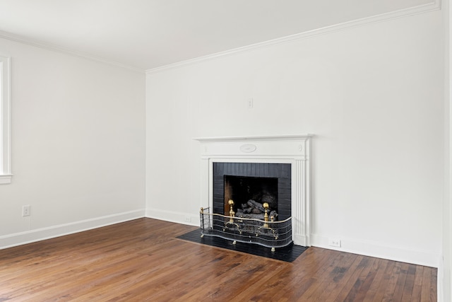 interior details with ornamental molding, a brick fireplace, baseboards, and wood finished floors