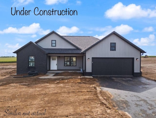 modern inspired farmhouse featuring a garage and aphalt driveway