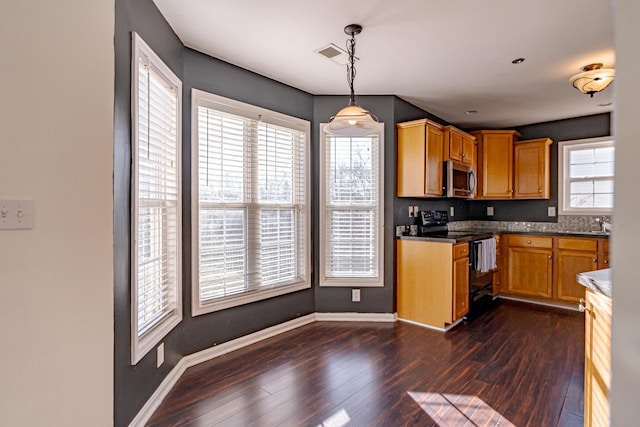 kitchen with dark wood-style floors, stainless steel microwave, visible vents, black range with electric cooktop, and baseboards