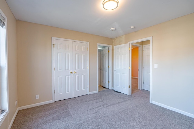 unfurnished bedroom featuring a closet, carpet flooring, and baseboards