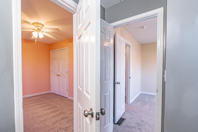 corridor featuring carpet, visible vents, and baseboards