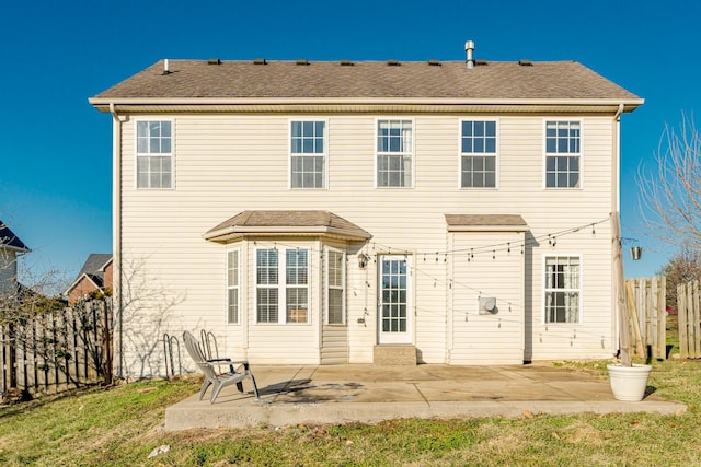 rear view of property with a shingled roof, a patio area, and fence