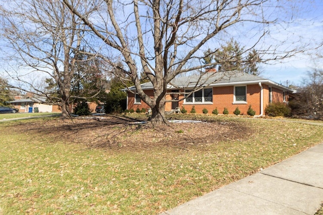 ranch-style house featuring brick siding and a front lawn