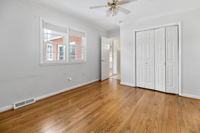 unfurnished bedroom featuring light wood-type flooring, baseboards, visible vents, and crown molding