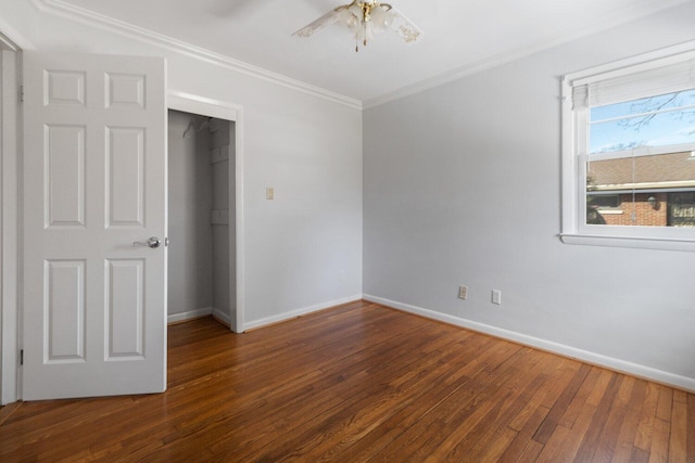 unfurnished bedroom featuring hardwood / wood-style flooring, ceiling fan, baseboards, and crown molding