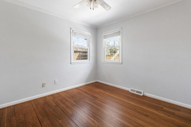 unfurnished room with hardwood / wood-style flooring, a ceiling fan, visible vents, baseboards, and crown molding