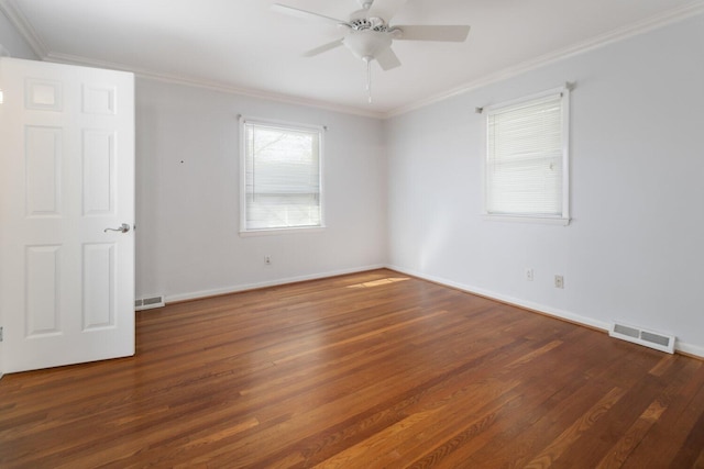 spare room with visible vents, wood finished floors, and ornamental molding