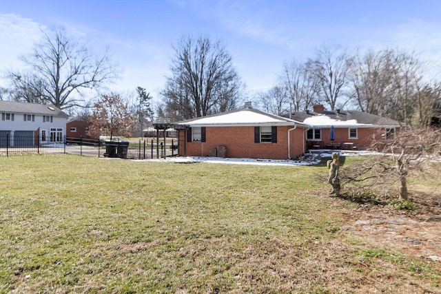 exterior space with a chimney, fence, a lawn, and brick siding