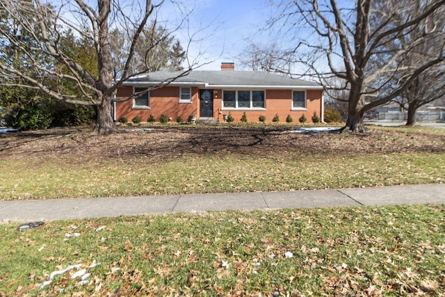 single story home with a chimney and brick siding