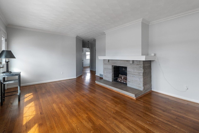 unfurnished living room with a stone fireplace, wood finished floors, visible vents, baseboards, and crown molding