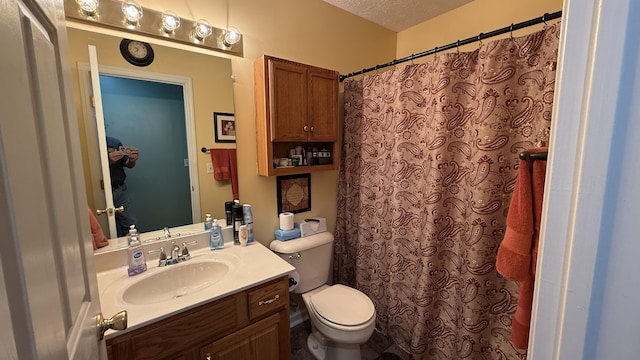 bathroom featuring curtained shower, vanity, toilet, and a textured ceiling